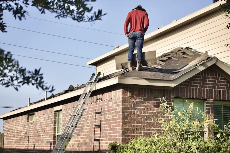 Professional roofer working on a residential roof in Marshfield Station
